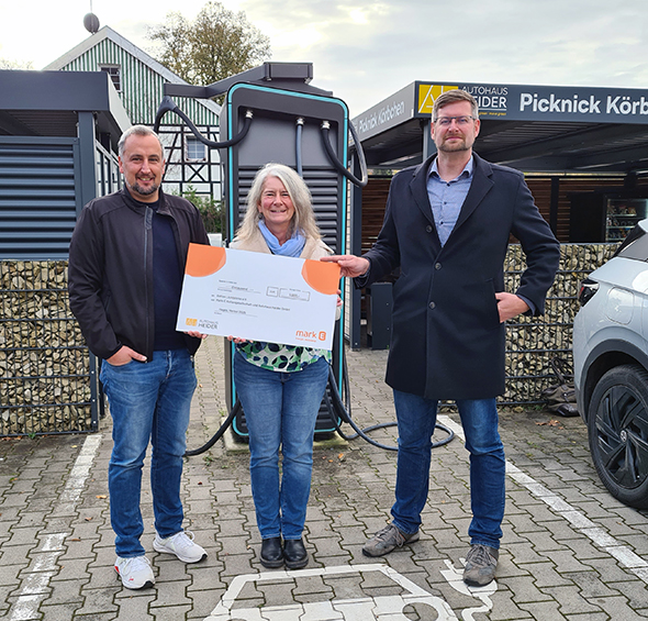 Übergabe des Spendenschecks für die Aktion Lichtblicke an Radio Hagen Chefredakteurin Cordula Aßmann (Mitte) durch Firmenchef Jan Heider (links) und Daniel Kruse, Leiter des Teams Elektromobilität bei Mark-E (rechts)