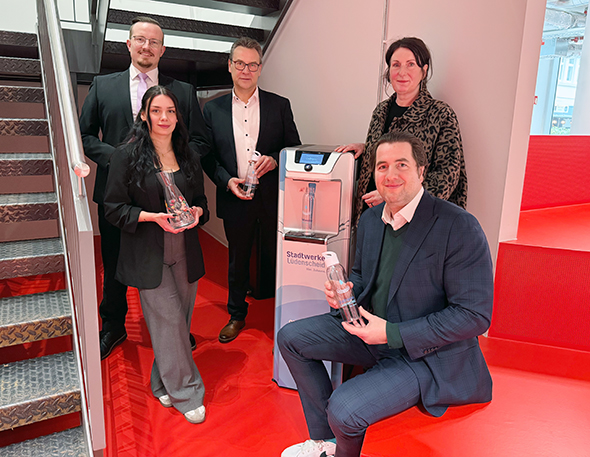 Ein Bild von der offizielle Inbetriebnahme des neuen Wasserspenders im TUMO Center Lüdenscheid mit Lucas Karich (Gesellschaftervertreter b.invest), Volker Neumann (Geschäftsführer Stadtwerke Lüdenscheid), Heike Müller-Bärwolf (Geschäftsführerin b.invest), Zülal Özleyen (Pädagogische Leitung TUMO Lüdenscheid) und Alexander ten Hompel (Stadtwerke Lüdenscheid, Leiter Marketing / Kommunikation)