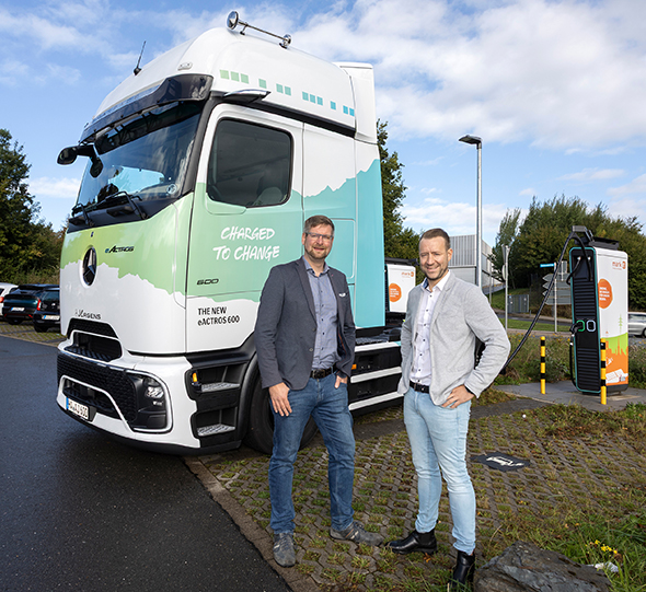Ein Foto der Vorstellung der Kooperation am Platz der Impulse in Hagen: Dr. Daniel Kruse, Leiter ENERVIE Team Elektromobilität (links) und Lars Siebert, Vertriebsteam Trucks Devision Jürgens Gruppe (rechts) vor einem E-Truck (eActross 600 Zugmaschine) an einer Schnellladesäule von Mark-E.