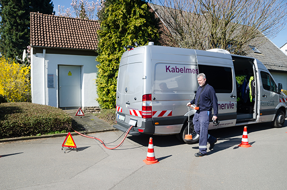 Ein Foto eines Kabelmesswagens und eines ENERVIE Mitarbeiters.