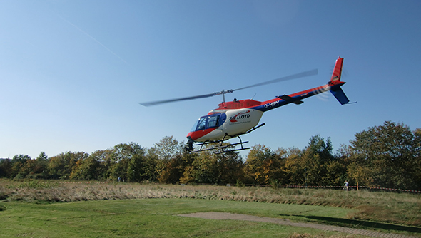Ein Foto eines Helikopters bei der Kontrolle von Hochspannungsleitungen.
